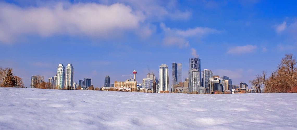 A vivid view of downtown Calgary from behind a snowy field.